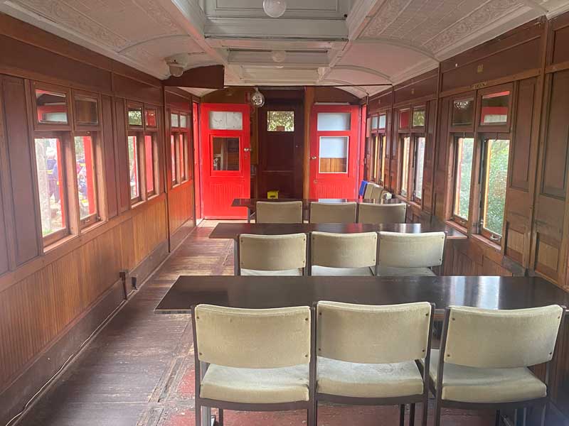 Inside of old train, chairs and tables