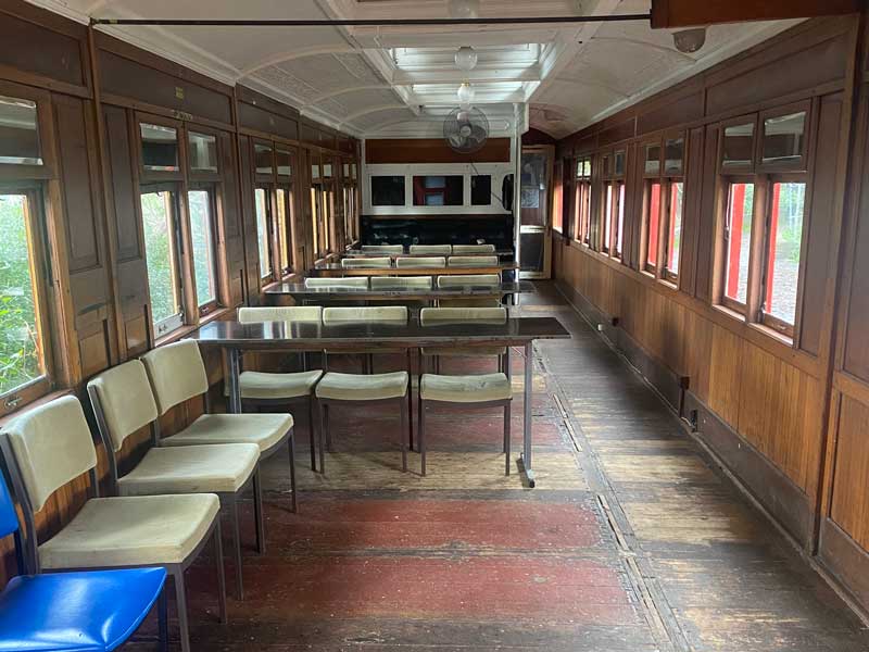 Inside of old train, chairs and tables